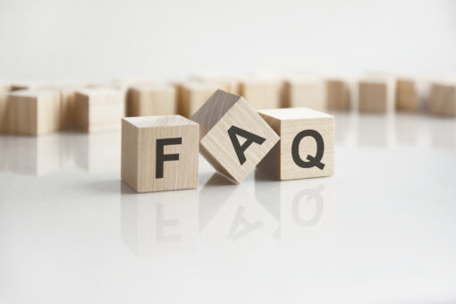 text faq on wooden blocks with letters on a white background. reflection of the caption on the mirrored surface of the table.